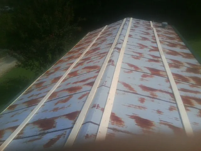 Rusted metal roof panels with new wood purlins before replacement — Storm Damage Roof Repair in Seabrook by Roofing Brothers